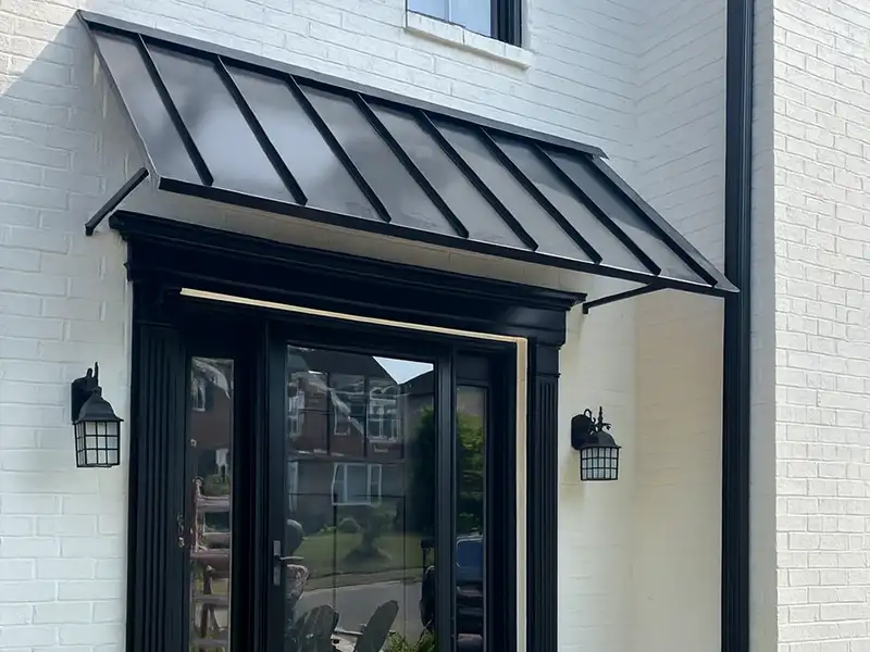black standing seam awning on residential brick home