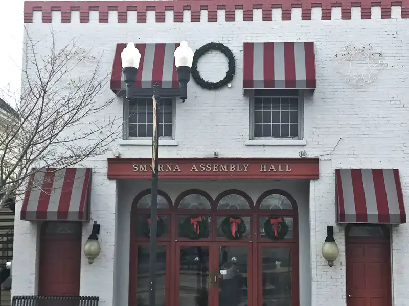 Custom striped fabric awnings installed on a brick commercial building facade.